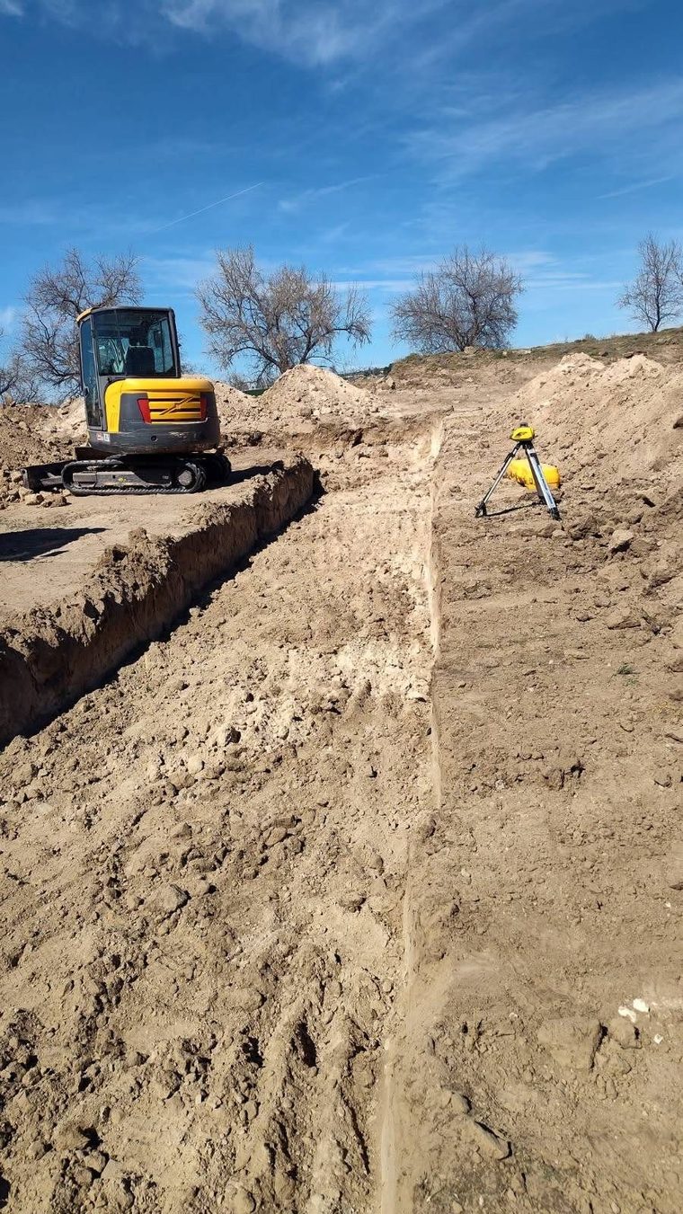 Footing trenches cut to grade with a laser level set on site.